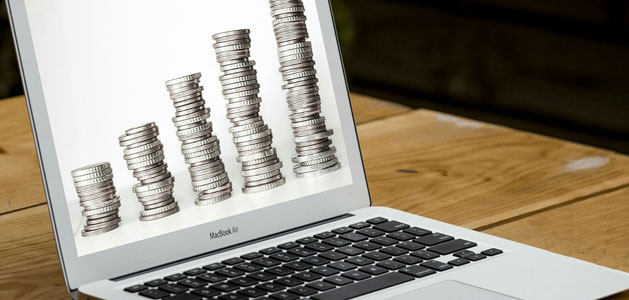 image of laptop with image of increasingly large stacks of coins